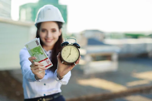 Business lady in hardhat with money on the roof