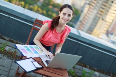 Çatıda dizüstü bilgisayar üzerinde çalışan kız