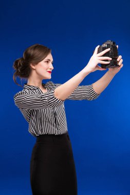 Elinde kamerayla gülümseyen kız