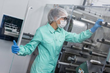 Fabrika içinde tank yakınındaki ayakta bilim adamı