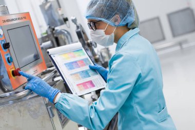 Fabrika içinde tank yakınındaki ayakta bilim adamı