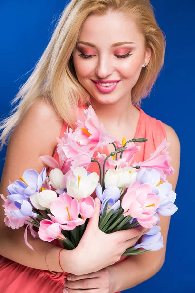 Ung flicka med blommor i händerna — Stockfoto