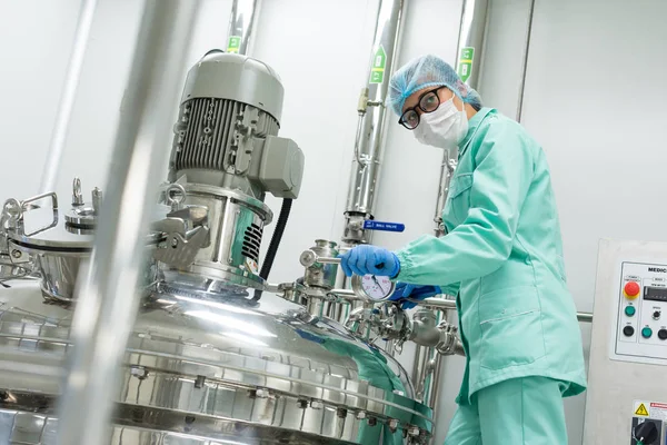 Wetenschapper permanent in de buurt van tank in fabriek — Stockfoto