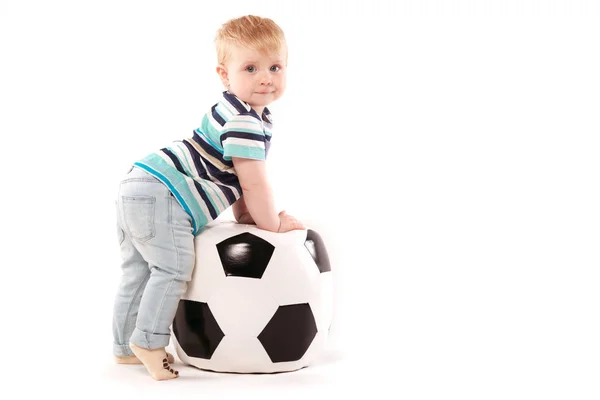 Ребенок забирается на футбольный мяч — стоковое фото