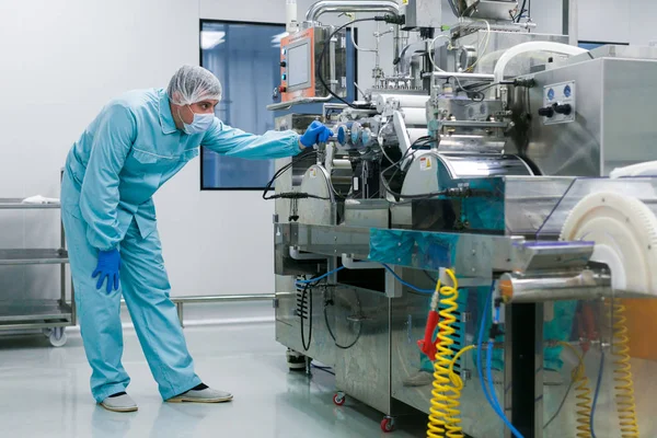 Wissenschaftler steht neben Maschine in Fabrik — Stockfoto