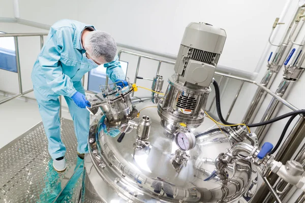 Wetenschapper werken met tank in fabriek — Stockfoto