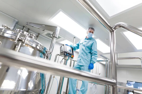 Scientist configures control panel near tank — Stock Photo, Image