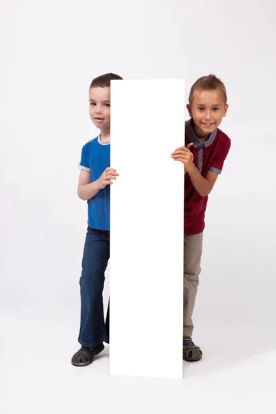 Niños de la escuela con cartel blanco — Foto de Stock