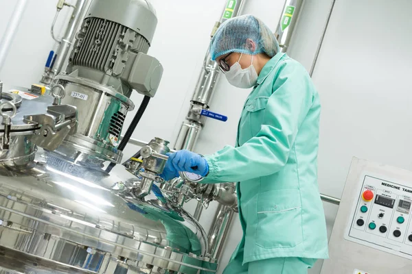 Cientista de pé perto do tanque na fábrica — Fotografia de Stock