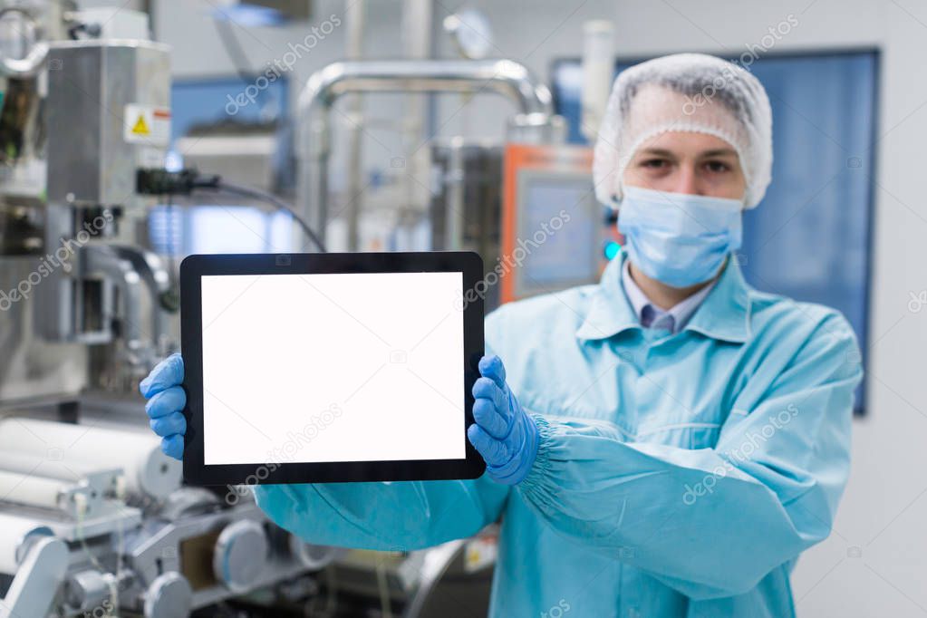 scientist with tablet by metal tank