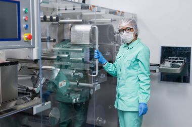 Fabrika içinde tank yakınındaki ayakta bilim adamı