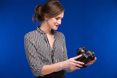 Elinde kamerayla gülümseyen kız