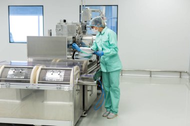 Fabrika içinde tank yakınındaki ayakta bilim adamı