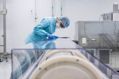 Fabrika içinde tank yakınındaki ayakta bilim adamı