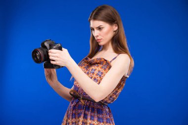 Elinde kamerayla gülümseyen kız