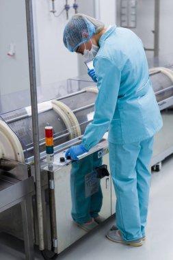 Fabrika içinde tank yakınındaki ayakta bilim adamı