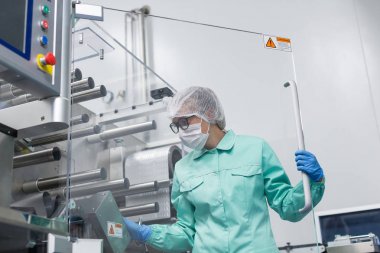 Fabrika içinde tank yakınındaki ayakta bilim adamı
