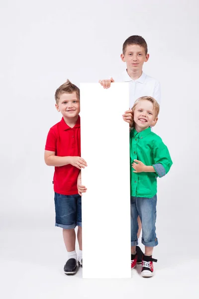 Meninos da escola com cartaz branco — Fotografia de Stock