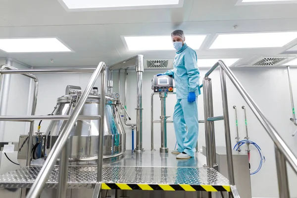 Scientist configures control panel near tank — Stock Photo, Image