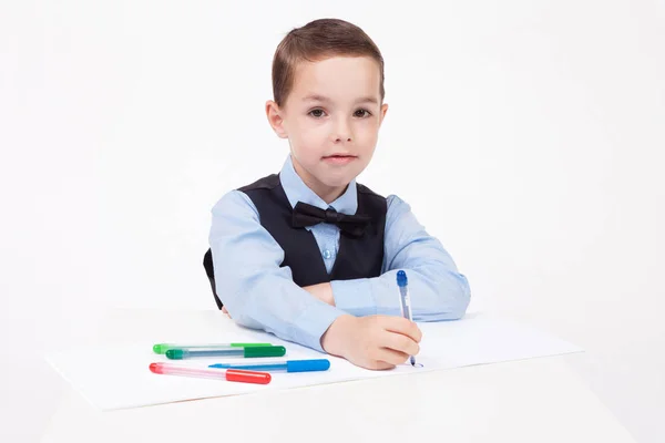 Маленький школьник рисует за столом — стоковое фото