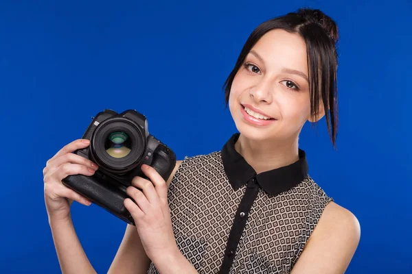 Lachende meisje met camera in handen — Stockfoto