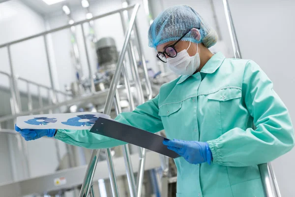 Scientist with tablet by machine at factory — Stock Photo, Image