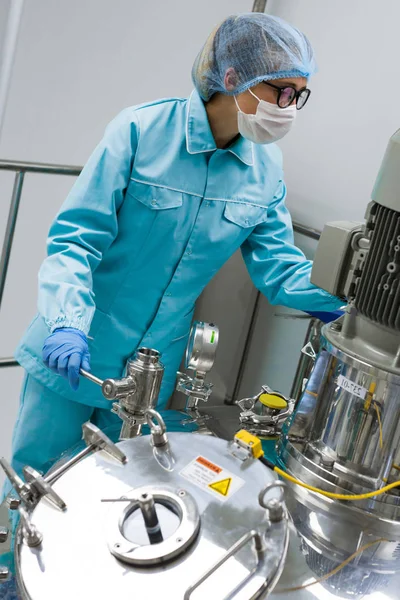 Scienziato in piedi vicino al serbatoio in fabbrica — Foto Stock