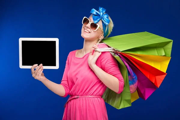 Chica rubia con bolsas de compras y tableta —  Fotos de Stock