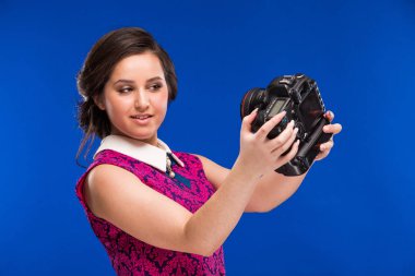 Elinde kamerayla gülümseyen kız