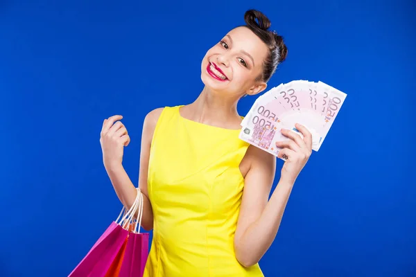 Chica morena con bolsas de compras y dinero —  Fotos de Stock