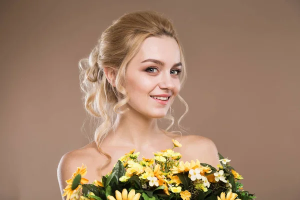 Ung flicka med blommor i händerna — Stockfoto