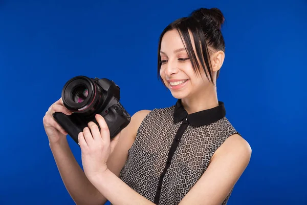 Lachende meisje met camera in handen — Stockfoto