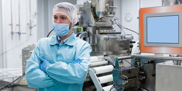 Cientista está de pé perto da máquina na fábrica — Fotografia de Stock