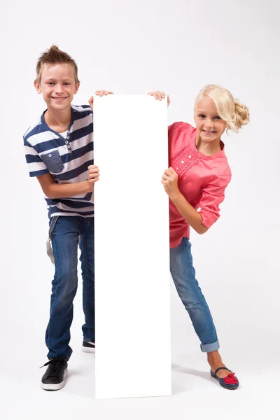 Gelukkig schoolkinderen met witte poster — Stockfoto