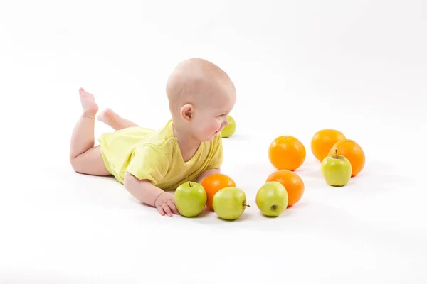 Cute boy with apples and oranges — Stock Photo, Image