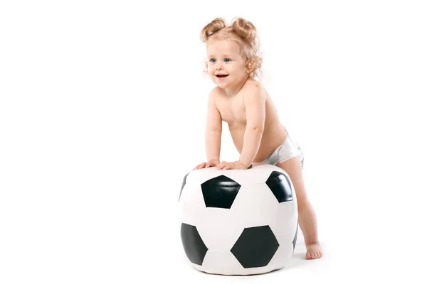 Ребенок забирается на футбольный мяч — стоковое фото