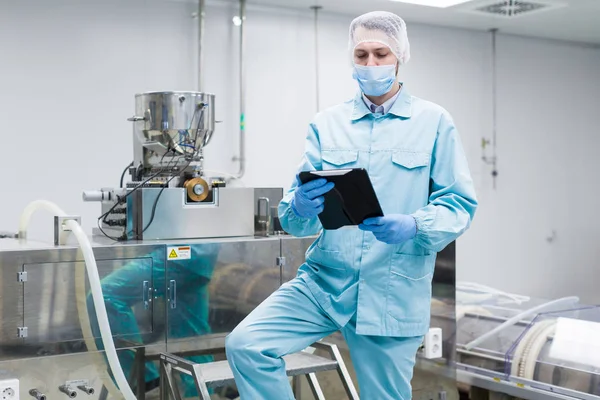 Scientist with tablet by metal tank — Stock Photo, Image