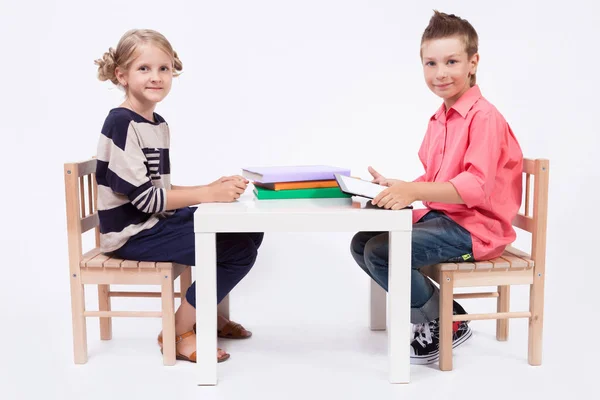 Dzieci w wieku szkolnym przy stole z książek — Zdjęcie stockowe