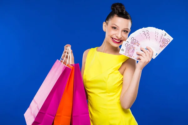 Brunette girl with shopping bags and money — Stock Photo, Image