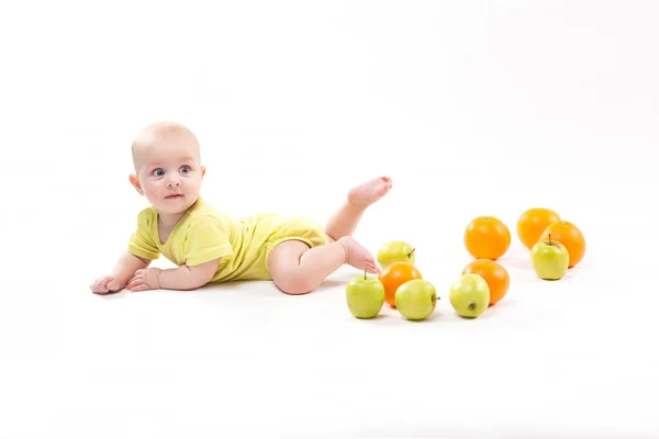 Smiling baby with apples and oranges — Stock Photo, Image