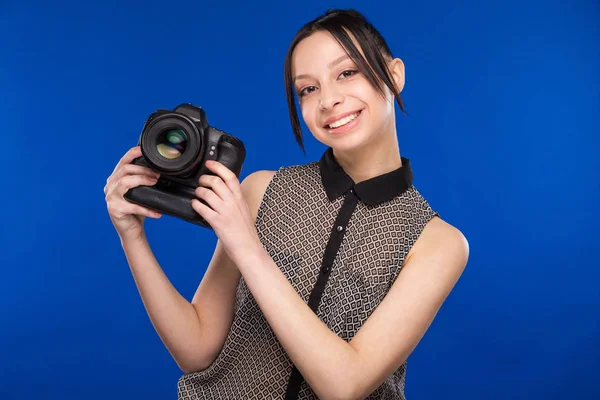 Lachende meisje met camera in handen — Stockfoto