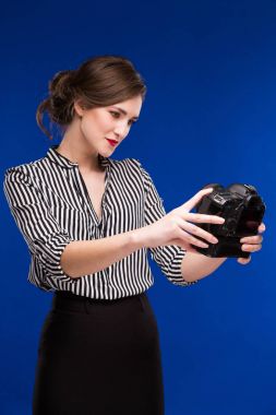 Elinde kamerayla gülümseyen kız