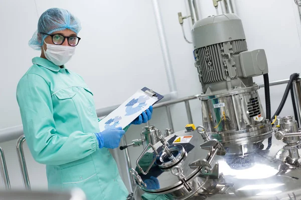 Scienziato in piedi vicino al serbatoio in fabbrica — Foto Stock