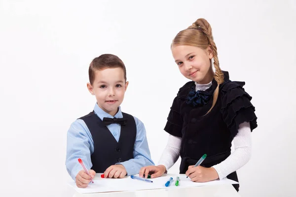 Kis iskolás és a lány egy asztalnál rajz — Stock Fotó