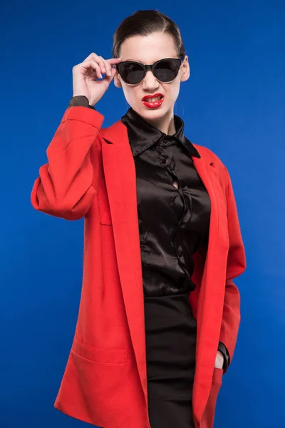 Chica en chaqueta roja y gafas de sol — Foto de Stock