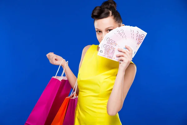 Chica morena con bolsas de compras y dinero — Foto de Stock