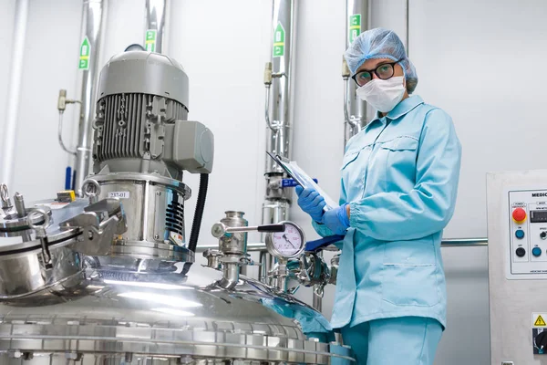 Cientista com tablet por máquina na fábrica — Fotografia de Stock