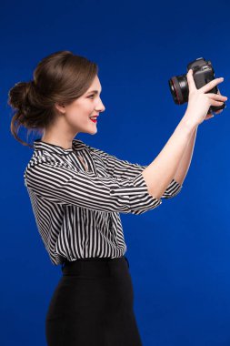 Elinde kamerayla gülümseyen kız