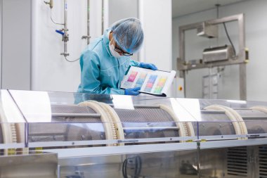 Fabrika içinde tank yakınındaki ayakta bilim adamı