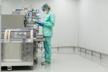 Fabrika içinde tank yakınındaki ayakta bilim adamı